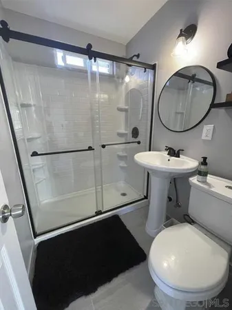 a bathroom with a toilet a sink and a mirror