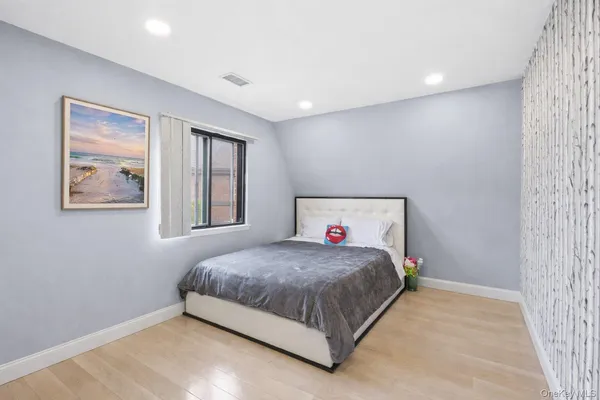 a bedroom with a bed and painting on the wall