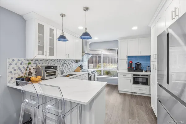 a kitchen with sink a stove and chairs