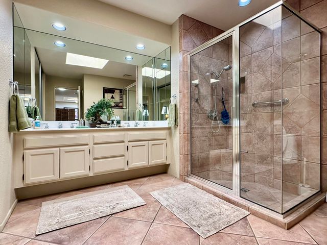 a spacious bathroom with a shower sink and mirror