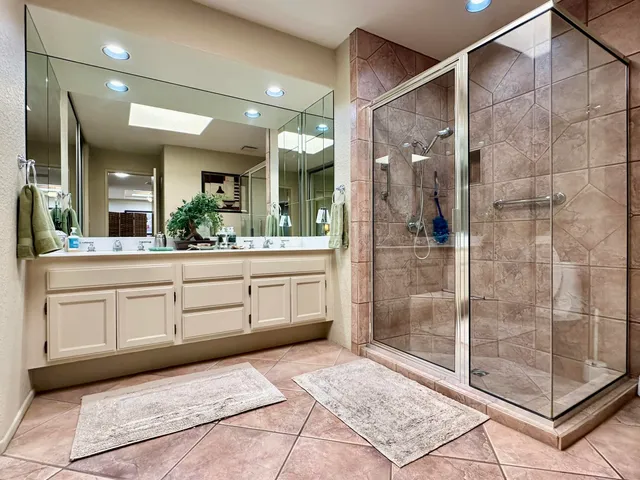 a spacious bathroom with a shower sink and mirror