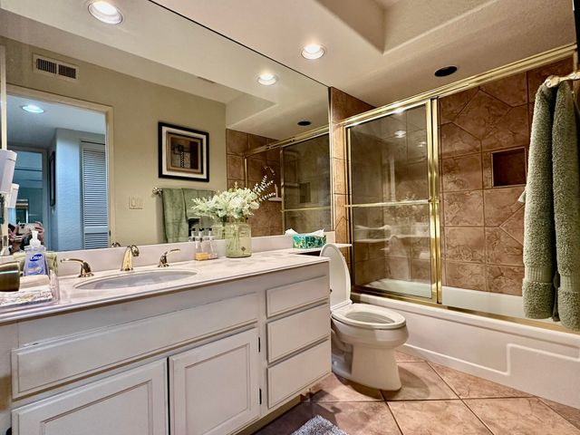 a bathroom with a double vanity sink toilet and shower