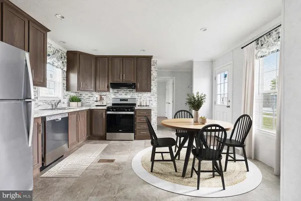 a kitchen with a table chairs refrigerator and cabinets