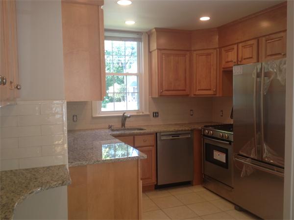 19 Brook Street, Unit 19 Wellesley, MA 02482 - Photo 6 of 13 a kitchen with granite countertop stainless steel appliances a refrigerator stove top oven and sink
