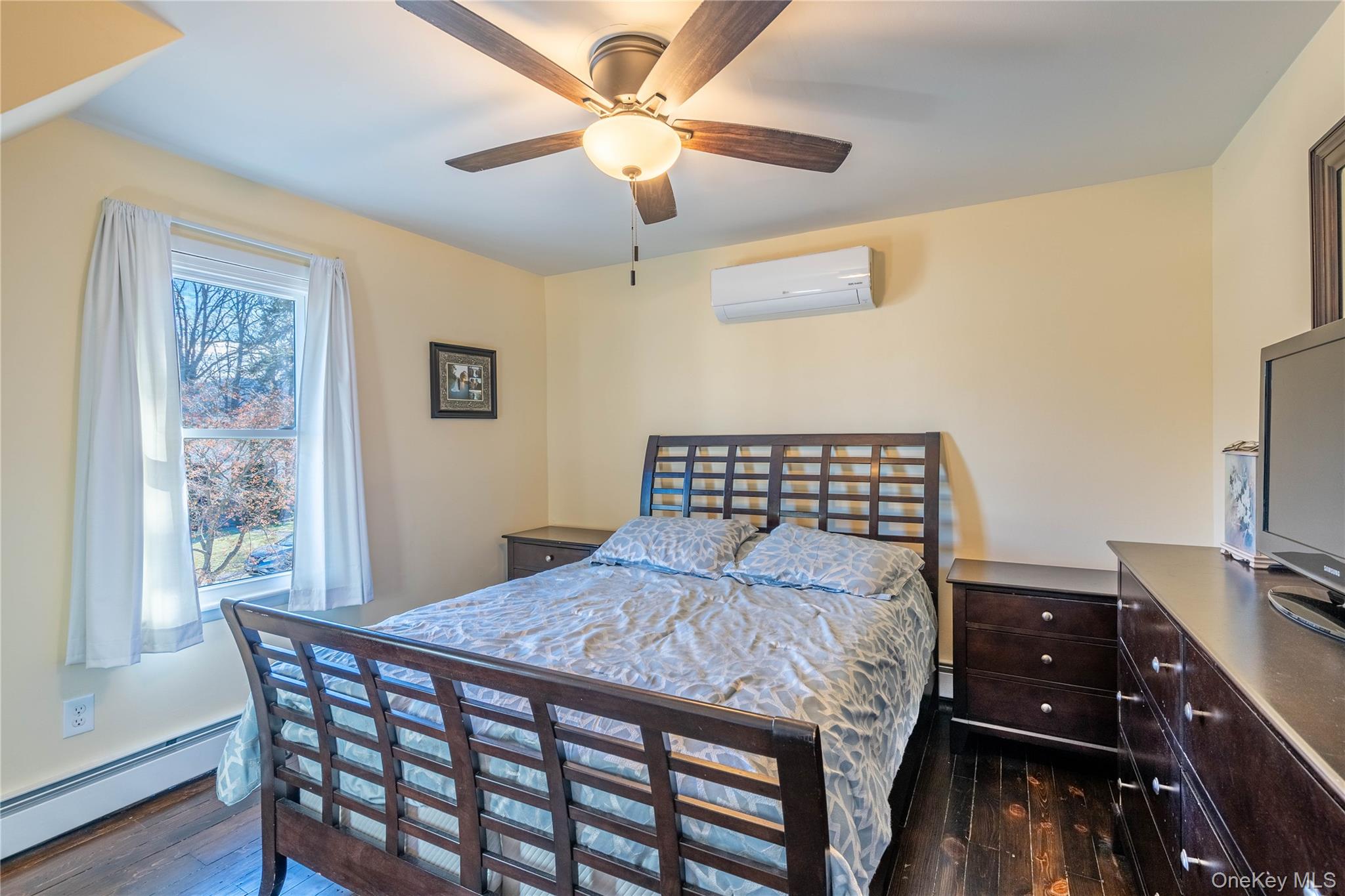 28 Maple Street Cornwall, NY 12518 - Photo 13 of 32 Bedroom featuring a baseboard heating unit, dark wood-type flooring, a wall mounted AC, and a ceiling fan