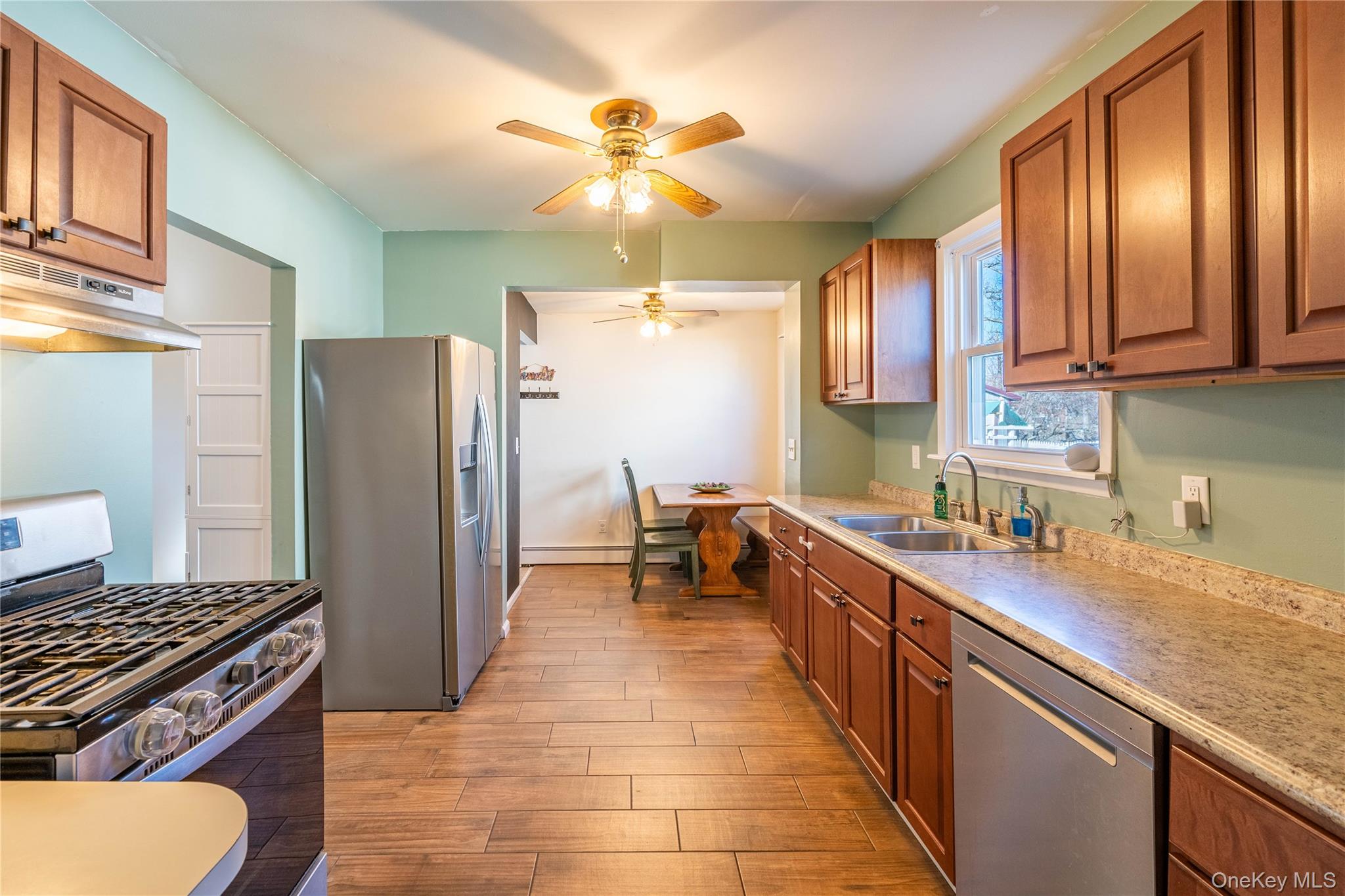 28 Maple Street Cornwall, NY 12518 - Photo 5 of 32 Kitchen with appliances with stainless steel finishes, brown cabinetry, and ceiling fan