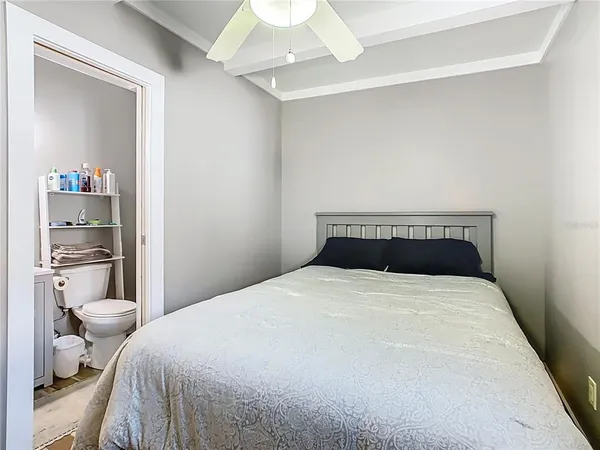 a bedroom with a large bed and a chandelier