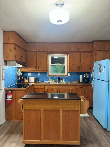 a kitchen with a refrigerator and a stove top oven