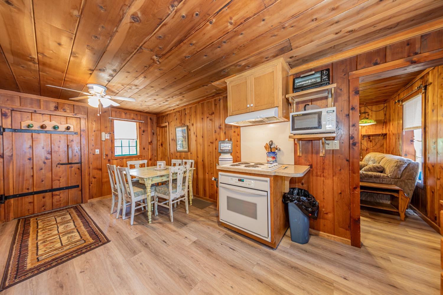 50054 Poplar Road Oakhurst, CA 93644 - Photo 12 of 34 a kitchen with stainless steel appliances granite countertop a stove a refrigerator a dining table and chairs with wooden floor