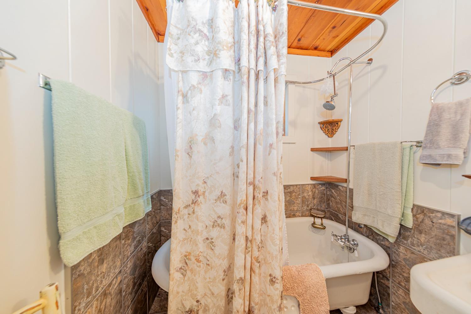 50054 Poplar Road Oakhurst, CA 93644 - Photo 19 of 34 a bathroom with a sink and mirror with bathtub