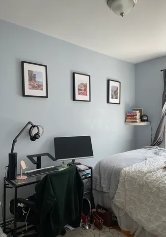 a bedroom with a bed and a computer on a desk