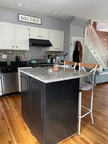 a kitchen with granite countertop a sink stove and cabinets