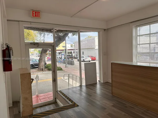 a living room with hardwood floor and large windows