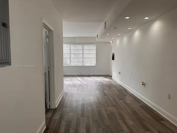 a hallway with wooden floor and front door