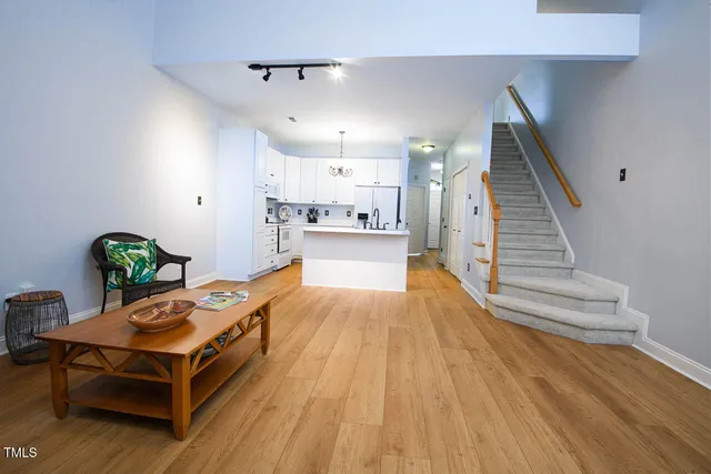 a living room with stainless steel appliances kitchen island granite countertop furniture and a wooden floor