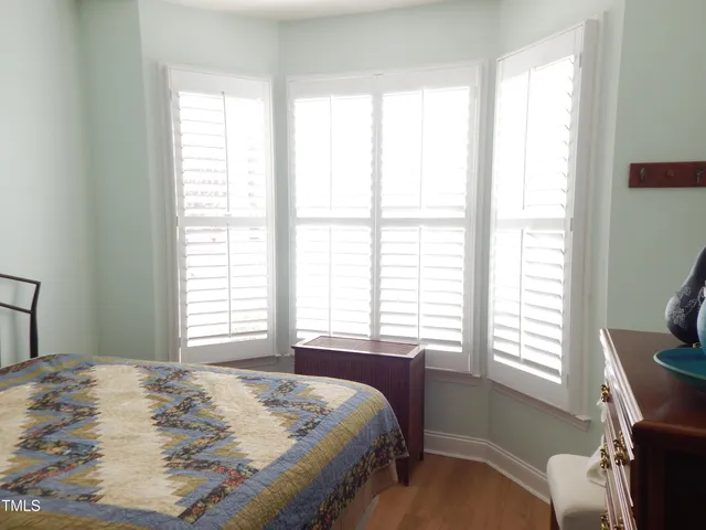 a bedroom with a bed and a window with chair