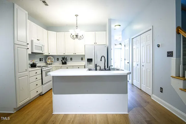 a view of kitchen with stainless steel appliances refrigerator stove microwave and cabinets