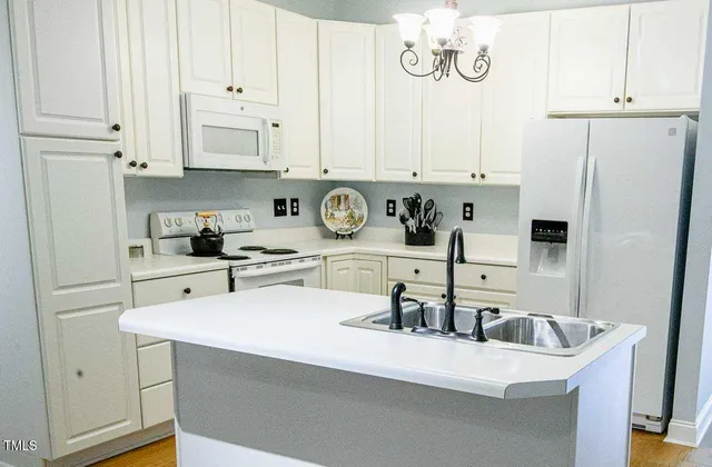a kitchen with kitchen island granite countertop a sink a stove and refrigerator