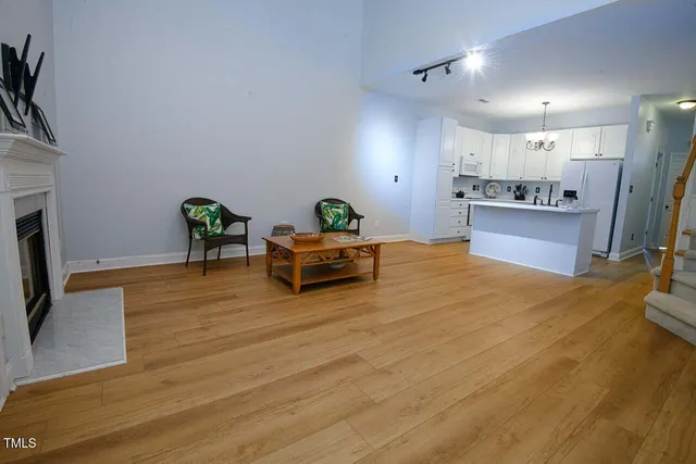 a large room with stainless steel appliances wooden floor large windows and a fireplace