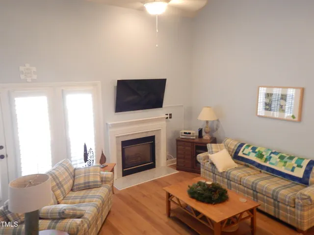 a living room with furniture a flat screen tv and a fireplace