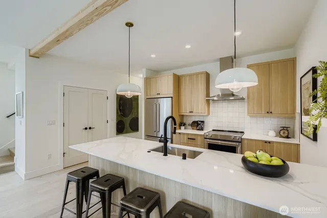 a kitchen with a sink a stove and chairs