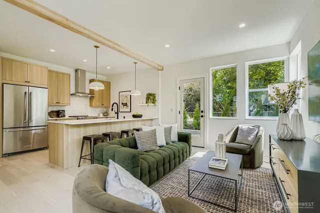 a living room with furniture a large window and kitchen view