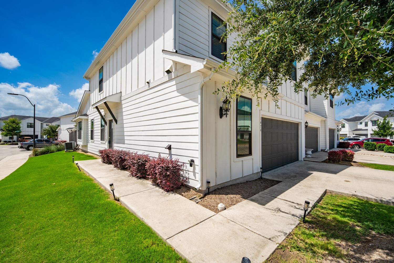 147 Waterside Road, Unit A Buda, TX 78610 - Photo 2 of 27 White siding and dark garages define the clean aesthetic of these inviting residences.