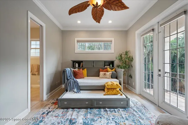 a spacious bedroom with a bed a flat screen tv and dresser