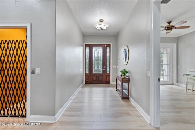 a living room with a wooden floor and a ceiling fan