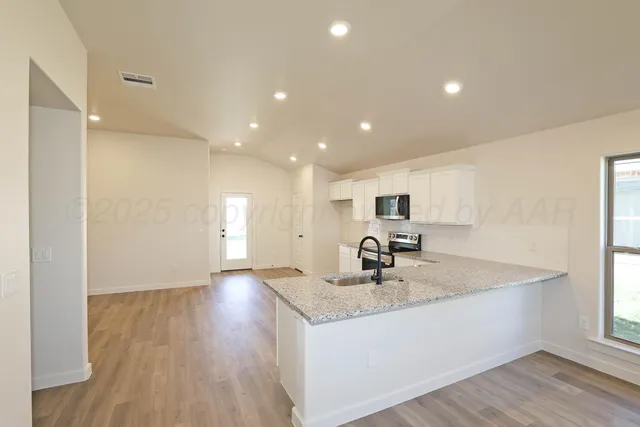 a kitchen with sink refrigerator and large window