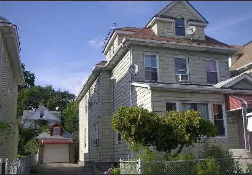 View of side of property with an outbuilding and a detached garage