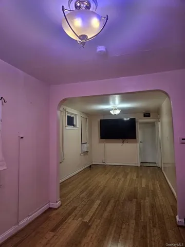 a living room with a floor to ceiling window and wooden floor