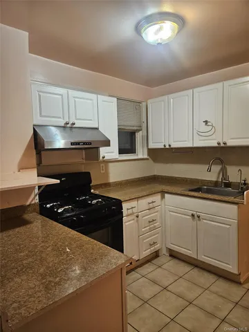 a kitchen with granite countertop a stove sink and cabinets