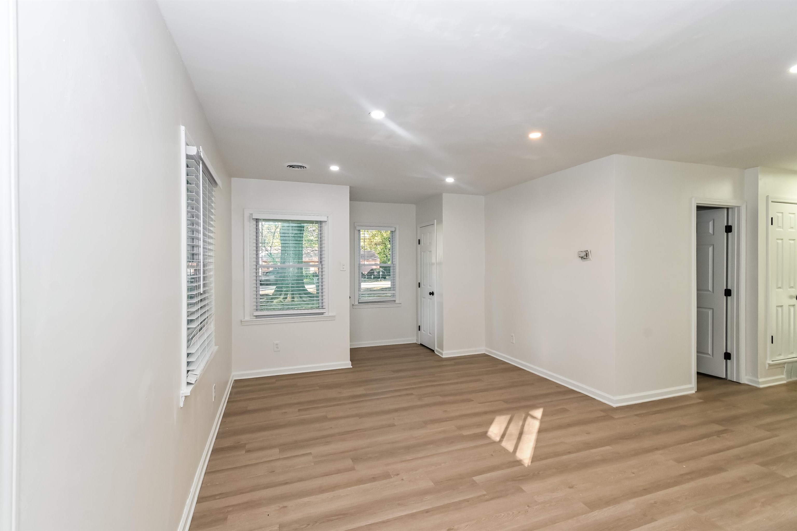 5264 Lochinvar Road Memphis, TN 38116 - Photo 3 of 13 a view of an empty room with wooden floor and a window