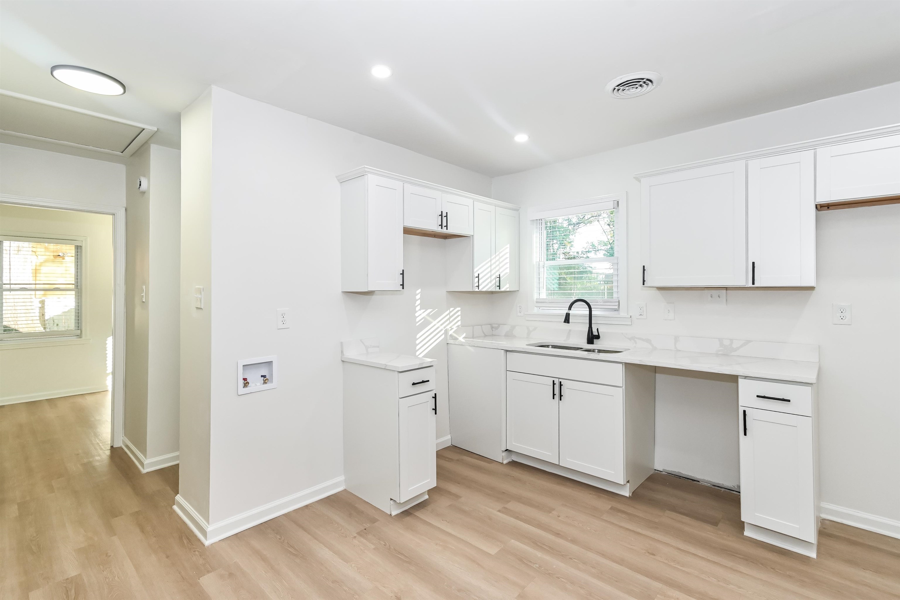 5264 Lochinvar Road Memphis, TN 38116 - Photo 5 of 13 a kitchen with white cabinets appliances and sink