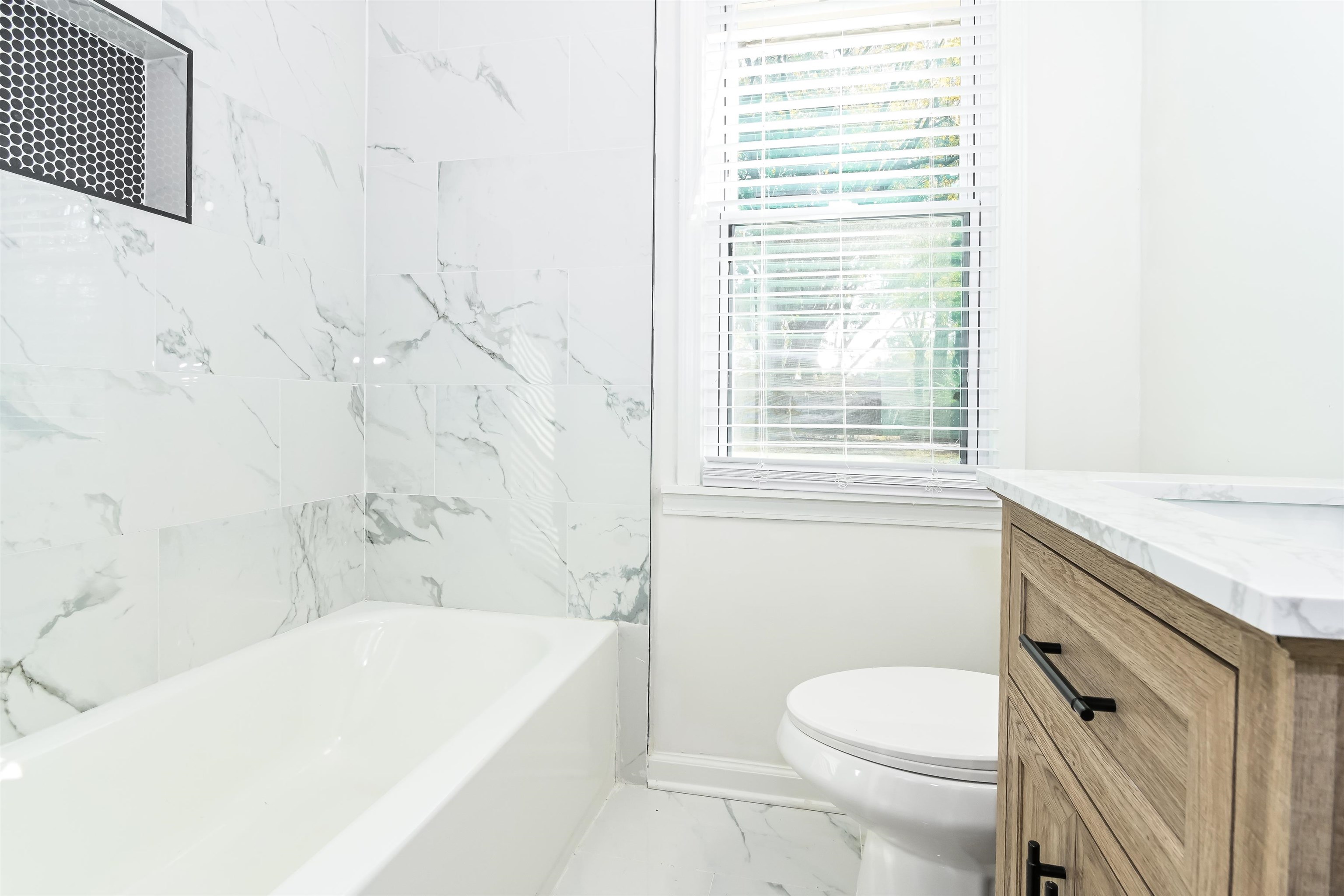 5264 Lochinvar Road Memphis, TN 38116 - Photo 10 of 13 a bathroom with a granite countertop toilet a sink and bathtub