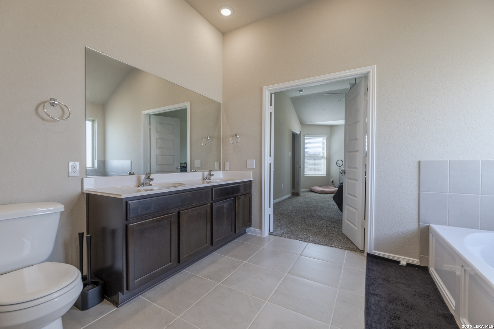 3035 Selhurst Street Converse, TX 78109 - Photo 10 of 18 a bathroom with a toilet a sink a mirror and a bathtub