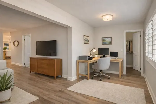 a work room with furniture a flat screen tv and a window