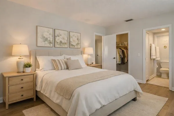 a bedroom with a bed and a lamp on dresser