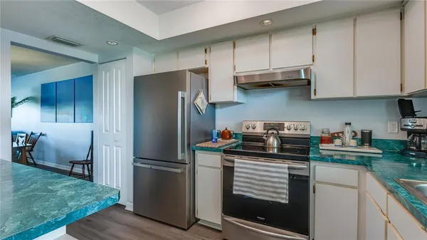 a kitchen with stainless steel appliances granite countertop a refrigerator sink and cabinets