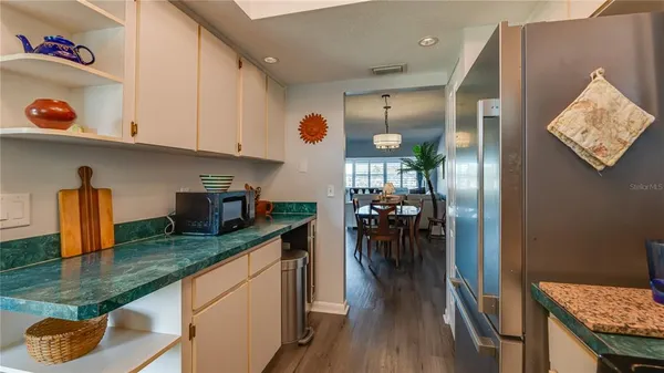an open kitchen with granite countertop lots of counter space and wooden floor
