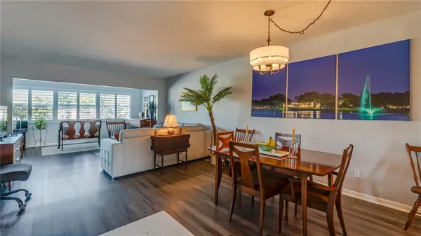a view of a dining room with furniture a chandelier and wooden floor