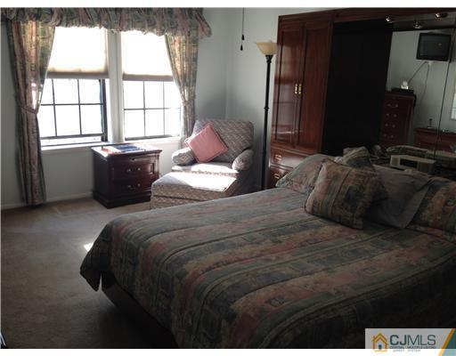 4402 Stonehedge Road Edison, NJ 08820 - Photo 14 of 25 a bedroom with a bed and wooden floor