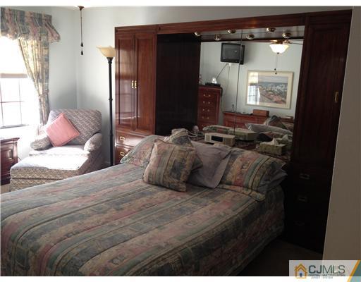 4402 Stonehedge Road Edison, NJ 08820 - Photo 15 of 25 a bedroom with a bed and wooden floor