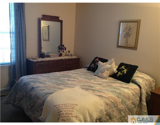 4402 Stonehedge Road Edison, NJ 08820 - Photo 21 of 25 a bedroom with a bed and a mirror