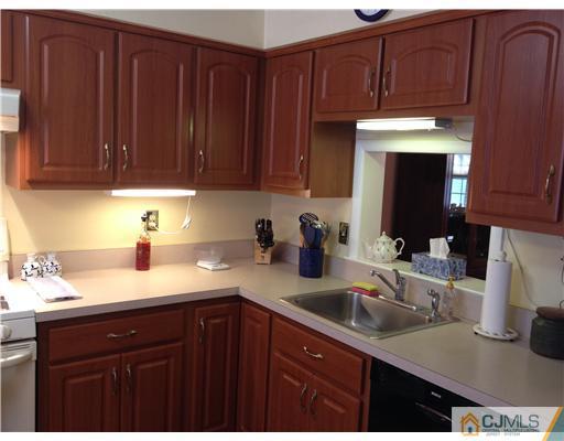 4402 Stonehedge Road Edison, NJ 08820 - Photo 7 of 25 a kitchen with kitchen island granite countertop a sink dishwasher stove and cabinets with wooden floor