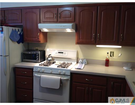 4402 Stonehedge Road Edison, NJ 08820 - Photo 8 of 25 a kitchen with stainless steel appliances granite countertop a sink stove and cabinets