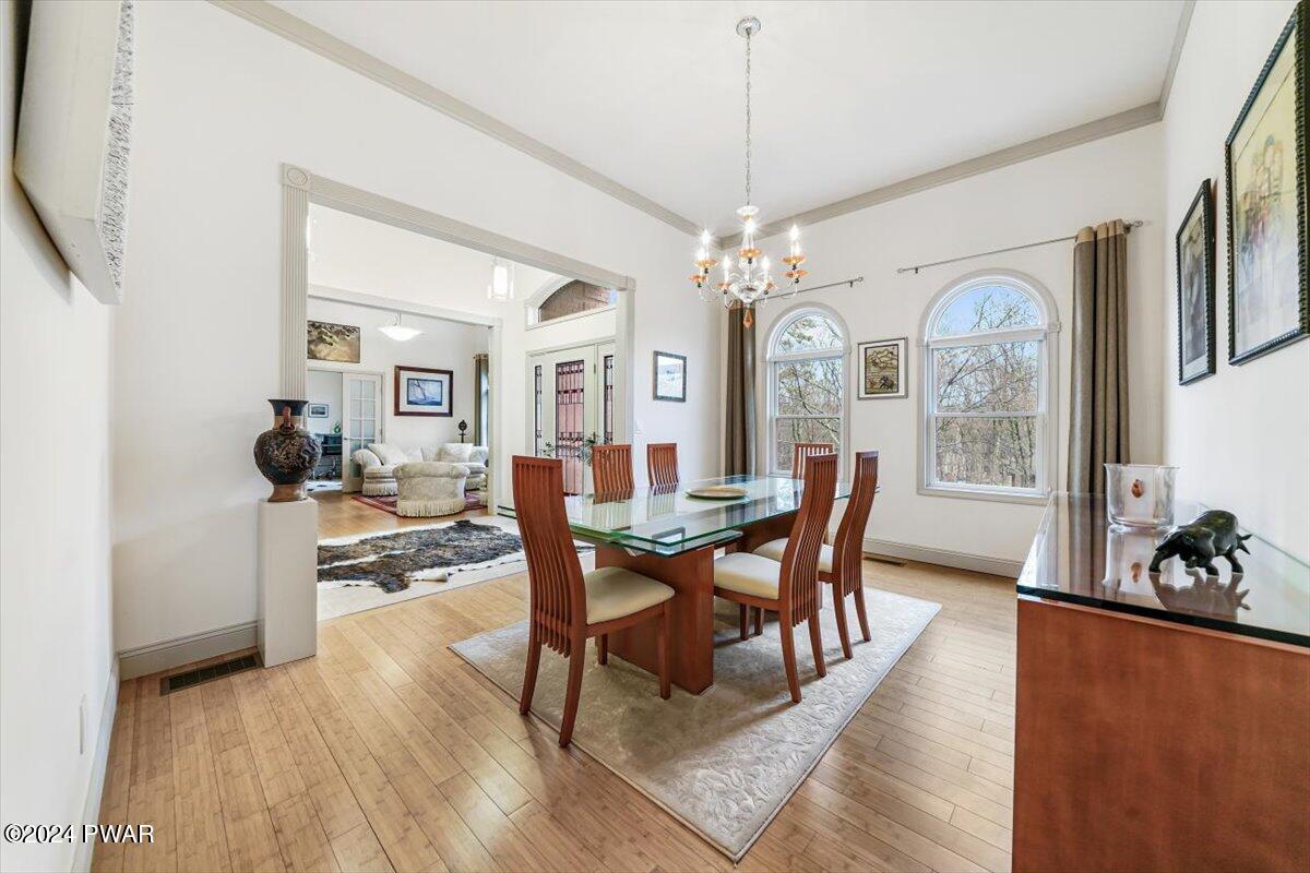 212 Rodeo Drive Hawley, PA 18428 - Photo 16 of 79 a view of a dining room with furniture a chandelier and wooden floor