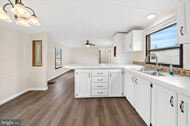 a kitchen with a sink cabinets and wooden floor