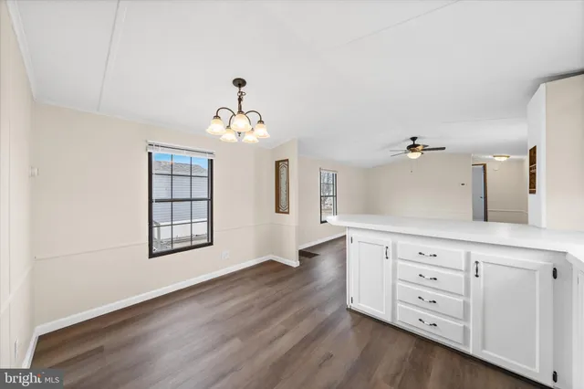 wooden floor with white cabinets and window